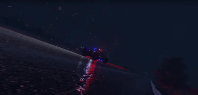 A police helicopter searchlight sweeping a dark road from above