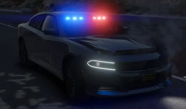 A Charger patrol unit with its light bar running on an empty street
