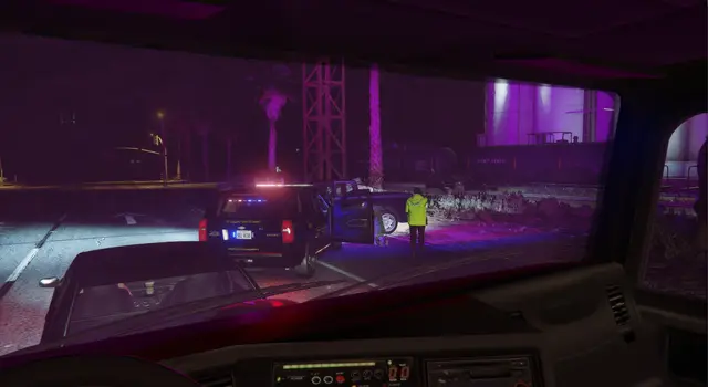An officer in a high-visibility jacket working a scene, seen from a car