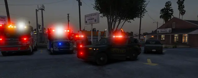 Patrol units stopped at an intersection at dusk with lights running