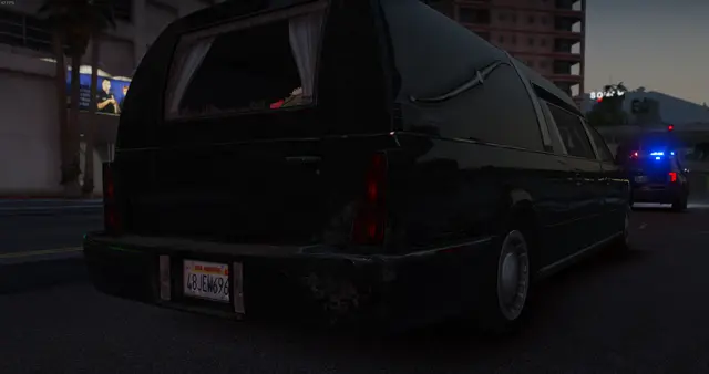 A black limousine on a city street with a patrol escort behind it
