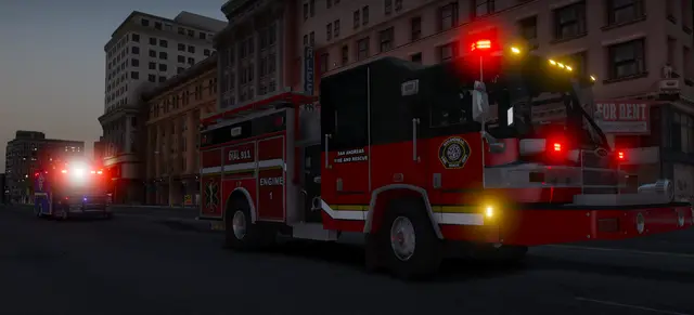 A fire engine responding through the city with its lights on