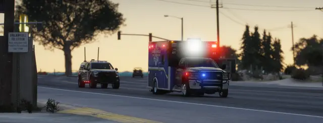 An ambulance and patrol units at a roadside scene in the evening