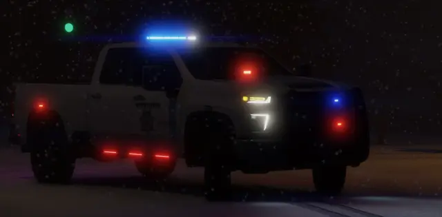 A pickup patrol unit on a dark road with its light bar running