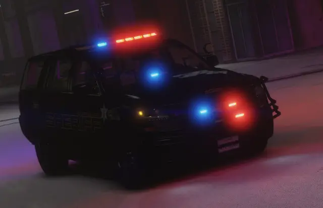 The rear of a patrol SUV with its lights running at night