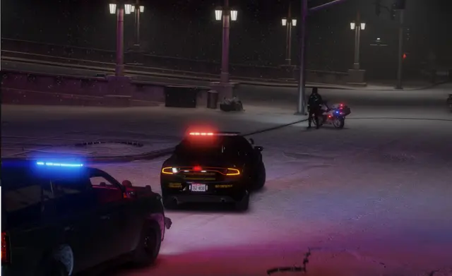 A patrol unit stopped at a distance on a snowy road