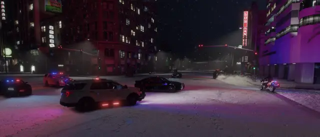 Patrol cars spread across a snowy city street at night