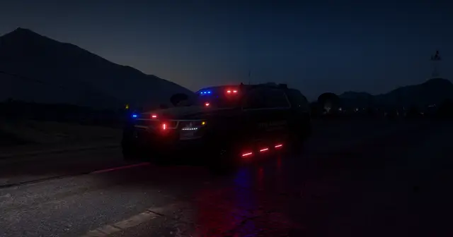 Patrol units on a dark road at dusk with rear lights lit
