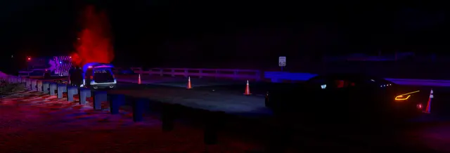 Cones and emergency lighting closing a road at night