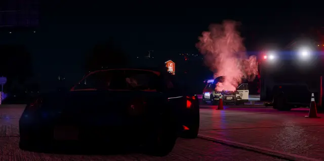 Emergency vehicles working a scene in red flare smoke